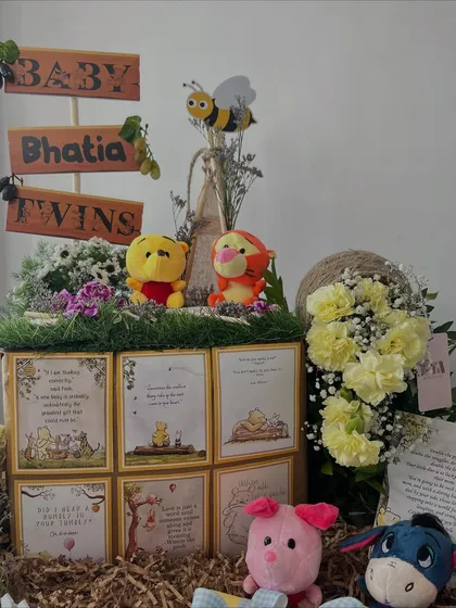 Another take on the Winnie the Pooh theme, this version for the 'Bhatia Twins' includes a rustic design with a picket fence, plush characters, and panels featuring heartwarming quotes from the classic stories.