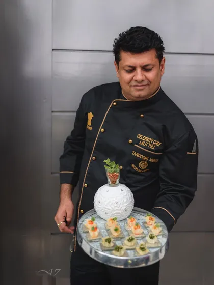 Here I am, presenting a tray of our bespoke canapés. My team and I pour our passion and expertise into every detail, ensuring your event is catered with a personal touch and culinary mastery.