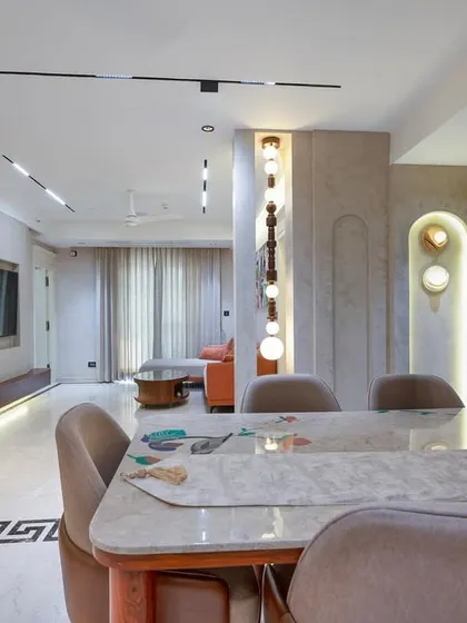 This view shows the open-plan layout connecting the dining and living areas. We used strategic lighting, including pendant lights and recessed fixtures, to define the different zones while maintaining a cohesive and spacious feel throughout the home.