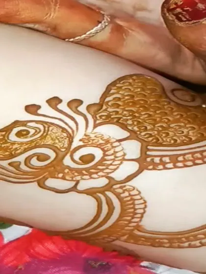 A close-up of the fresh henna paste application. This shows the clean, confident lines I use to create a traditional peacock motif.
