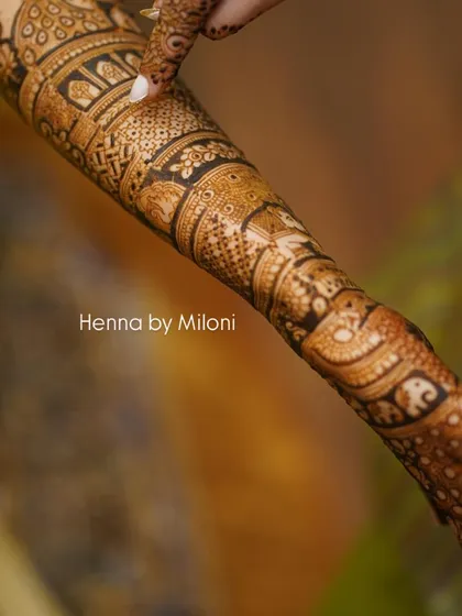 A detailed close-up of a bridal arm, showcasing the fine line work and shading.