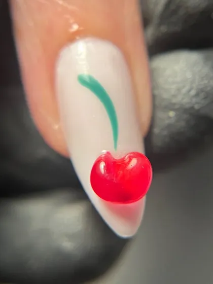 A macro shot of the super cute 3D jelly cherry. This little detail adds a fun, playful touch to the entire manicure.