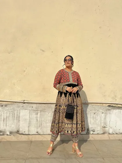 The simplicity of the black potli ensures it complements, rather than competes with, a heavily detailed outfit.