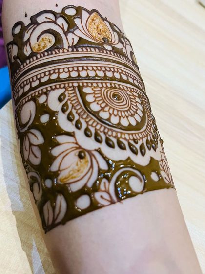 A detailed look at a floral and mandala arm band. The combination of bold lines and delicate shading creates a design with a lot of depth and texture.