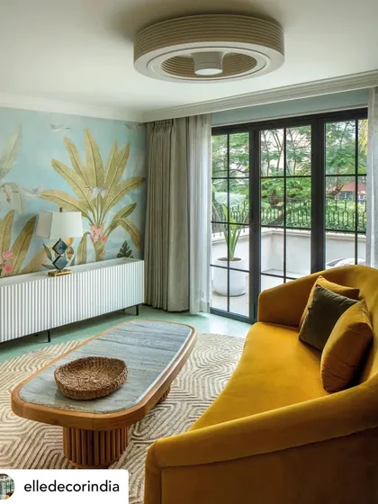 The 'Summer Haus' living room, featured on the cover of Elle Decor, captures our philosophy of designing 'between calm and colour'. A vibrant yellow sofa and tropical wallpaper are balanced by soft, neutral textiles, creating a space that is both energetic and serene.