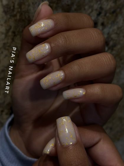 This is a structured manicure using a flexible rubber base gel in a nude shade with delicate gold flakes. It adds strength to your natural nails while looking incredibly chic.