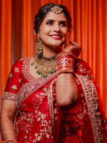 The getting ready moments are full of emotion. This North Indian bride's happy smile as she puts on her jewelry shows the excitement building up before she walks down the aisle.