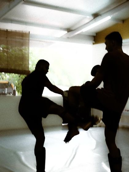 A silhouetted shot of a sparring exchange, capturing the dynamic movement and energy of a live drill.