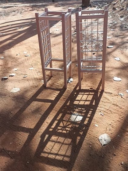 The same Kumiko lamp frames casting long shadows in the sun. The interplay of light and shadow is a key element of Kumiko design, beautiful both in the finished product and during its creation.