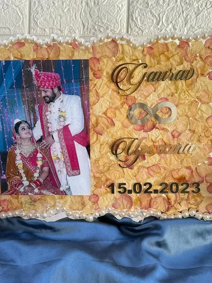 The frame displayed on a blue cloth, highlighting the soft colors of the petals and pearls.