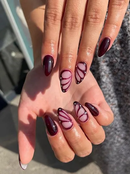 A stunning butterfly wing design in a deep maroon shade on a sheer base, accented with tiny silver dots.