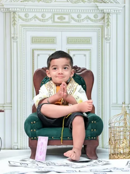 A playful and cheeky expression from the toddler during his vintage photoshoot. His crossed legs and thoughtful look add a lot of personality to this classic portrait.