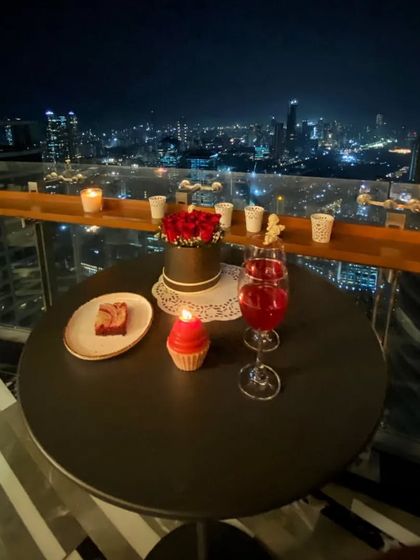 The full nighttime scene, with the candlelit table set for a romantic evening. This is how you create a special experience right at home, using your outdoor space to its full potential.