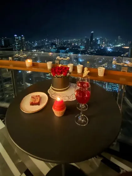 The full nighttime scene, with the candlelit table set for a romantic evening. This is how you create a special experience right at home, using your outdoor space to its full potential.