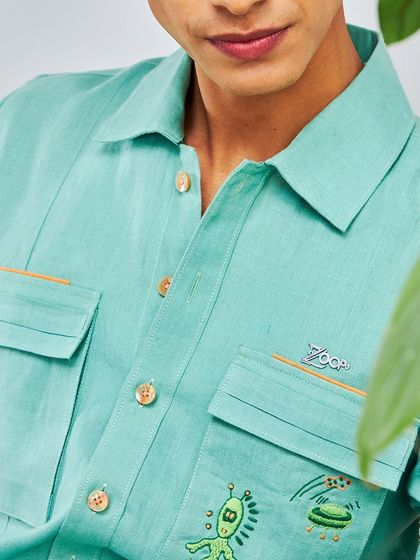 A close-up on the details. This shot shows the quirky alien embroidery and custom ZOOP pin on a mint green shirt from the Antriksh collection.
