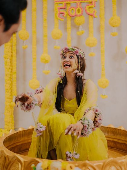 A moment of pure, surprised joy on the bride's face during her Haldi ceremony, making for a fun and memorable candid shot.
