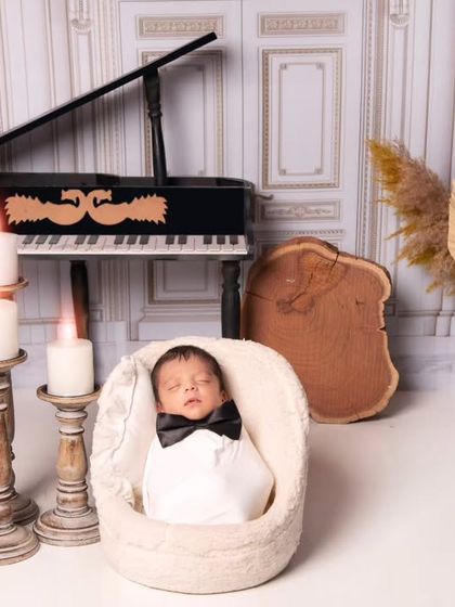 Dressed in a tiny tuxedo-style wrap with a black bow tie, this newborn looks like a little maestro. This shot showcases our attention to detail in styling.