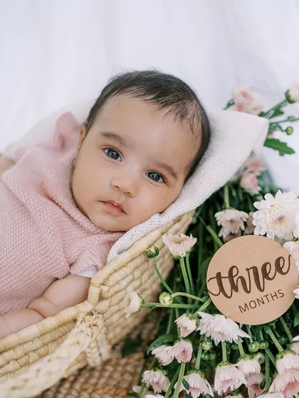 A beautiful portrait of the baby girl at three months, with a wooden milestone marker. These props add a lovely touch to the photos.