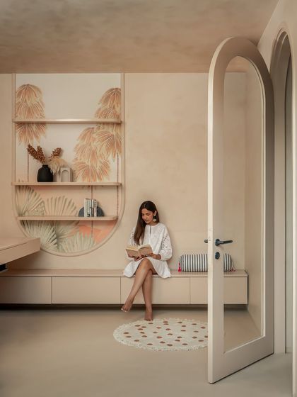 The arched passageway leads from the living area to the study, with the client's own hand-painted artwork creating a personal and artistic transition between the spaces.