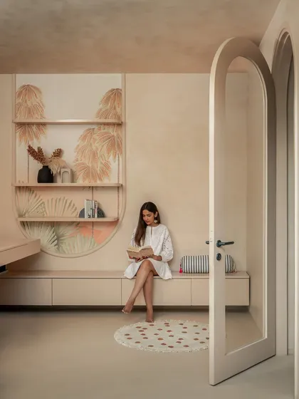 The arched passageway leads from the living area to the study, with the client's own hand-painted artwork creating a personal and artistic transition between the spaces.