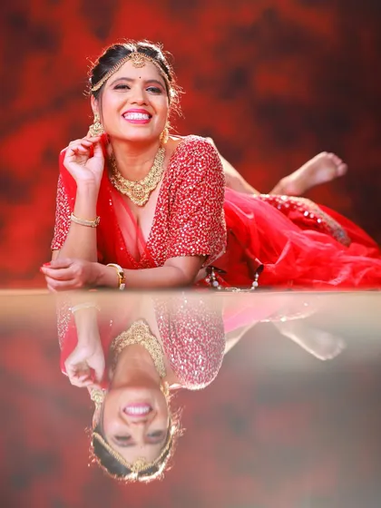 In the studio, we can play with creative techniques like reflections. This shot of a festive red lehenga uses a reflective surface to create a unique, symmetrical portrait that adds an artistic flair to a fashion shoot.