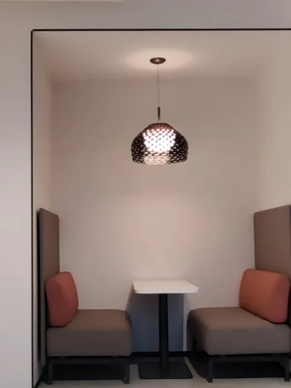 I design functional zones for modern offices, like this private pod. The high-back seating and enclosed design provide a quiet space for calls or focused work within an open-plan environment.