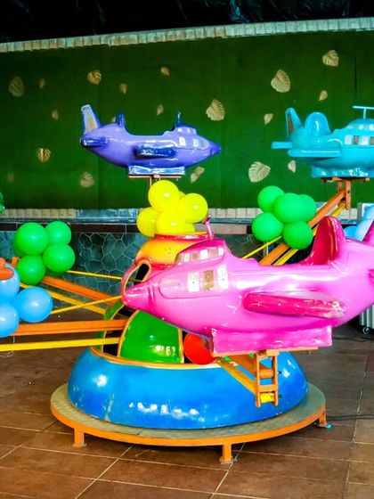 Another view of our colorful airplane carousel, showcasing the variety of bright, cheerful planes available for kids to ride.