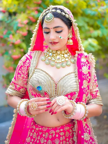 This shot focuses on the intricate details of the bridal blouse and the delicate peacock feather prop.