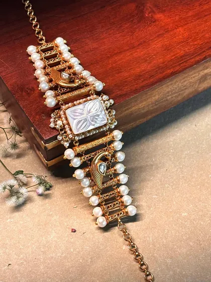 Festive charm in its finest form. A delicate bracelet featuring a mother-of-pearl centerpiece with swan motifs and pearl accents.
