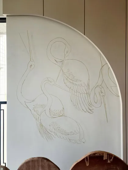 The pencil outline of the crane mural on the wall, just before the painting began. It’s a glimpse into the very first step of creating this stunning feature wall.