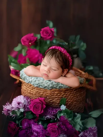A classic basket pose surrounded by fresh roses. This setup is perfect for creating a timeless and beautiful newborn portrait.