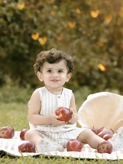An artistic shot of a baby boy at his apple-themed picnic, with a special lens effect creating heart-shaped bokeh in the background. This shows my ability to add a touch of magic to outdoor shoots.