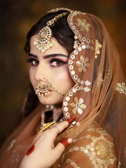 A side profile of the bride, showing the detailed hair and dupatta setting.