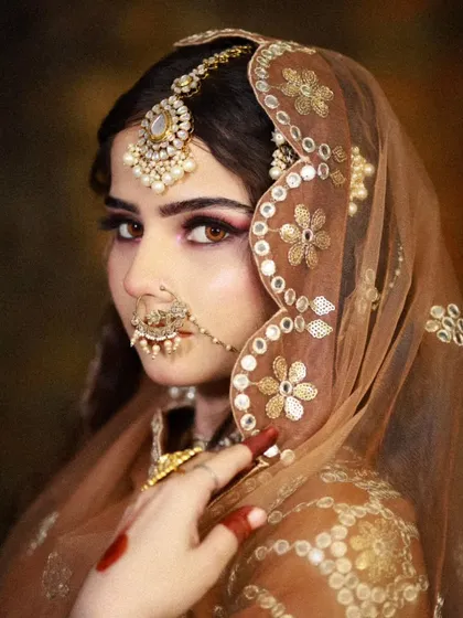 A side profile showing the delicate nath and the sheer, embroidered dupatta. I teach how to balance heavy jewelry with the right makeup intensity.