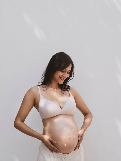 A sweet and tender maternity portrait, with the mother-to-be smiling down at her belly. A moment of pure love and anticipation.