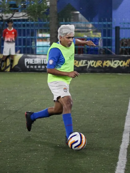 Age is just a number here. One of our senior players, with his distinctive silver hair, skillfully controls the ball during a match, proving that passion and technique have no age limit.