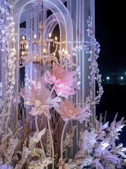 A close-up of the stage details, featuring oversized, handcrafted paper flowers nestled within the crystal-like structures. These artistic elements add a touch of whimsy to the grand design.