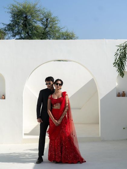 A full view of the stunning red sequin saree and black bandhgala combination, perfect for a pre-wedding shoot or a glamorous event.