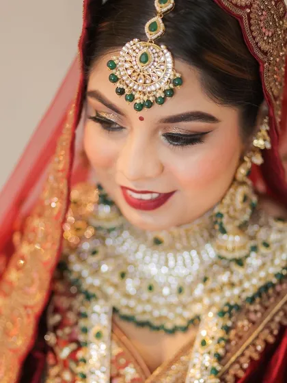A beautiful close-up of the bride, highlighting her flawless makeup, sparkling maang tikka, and serene expression.