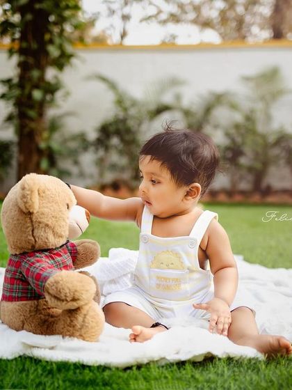 A nine-month-old baby having a picnic with his favorite stuffed animals. A simple and sweet outdoor theme.