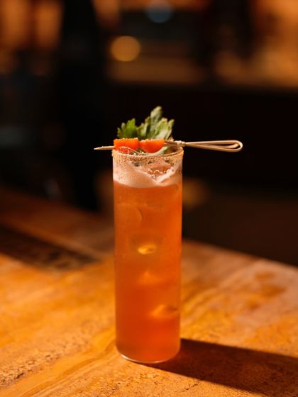A full view of the refreshing Smoky Spritz, garnished with celery and tomato, highlighting its savoury and unique flavour profile.