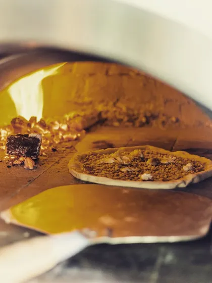 Opening soon. A pizza bakes in the glowing heat of our wood-fired oven, a promise of the delicious food to come.
