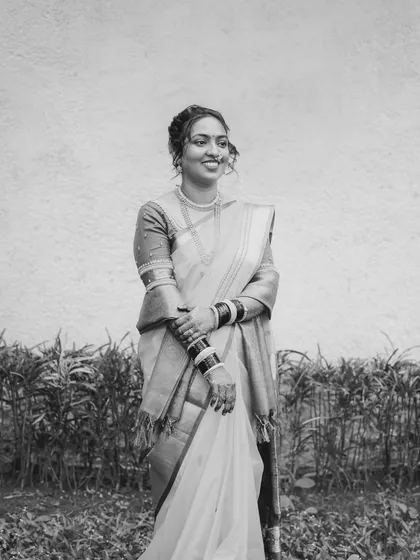 A timeless black and white portrait of a bride, capturing her happy expression and the beautiful drape of her saree.