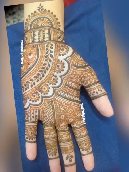 A classic mandala-style design on the back of the hand, focusing on symmetry and clean, flowing lines.