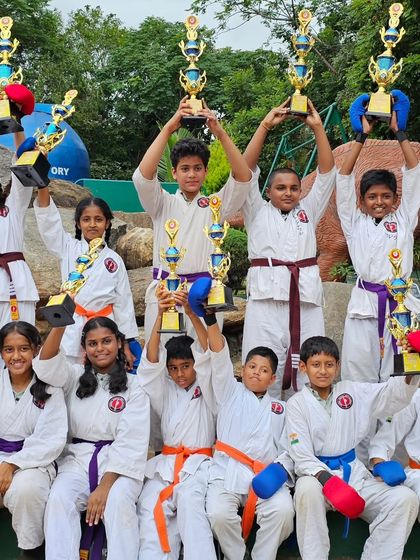 The joy of a team victory. Students holding their trophies high, a testament to their collective effort and the supportive environment at our academy.