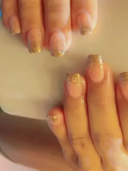This is a glitter fade French manicure, also known as a glitter ombre. I used gold glitter that fades down from the tip of these square-shaped nails.