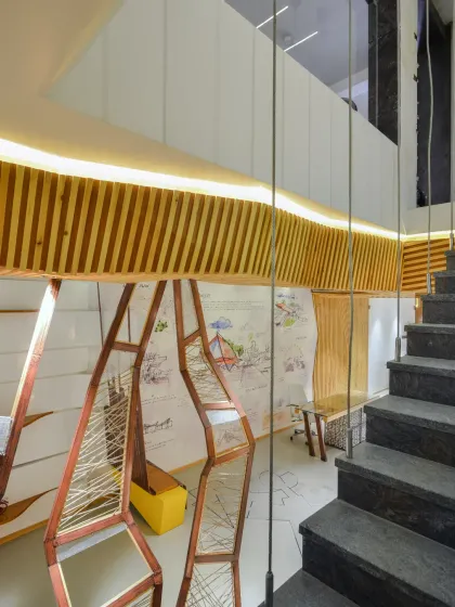 A detail of the harmonious interplay of materials at the AMG office. The solidity of granite on the staircase is balanced by the warmth of maple wood and a touch of green astroturf, creating an environment that is both inviting and professional.