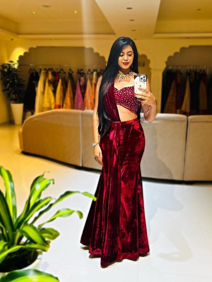 For a sizzling reception or cocktail look, I designed this maroon velvet outfit. It features a sleek fish-cut skirt paired with a dazzling crystal-embellished blouse and a pre-draped dupatta for effortless glamour.