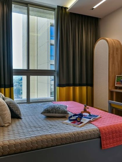 This shared bedroom for two brothers is a sanctuary designed to grow. Sunshine yellow is balanced by calming grey, while natural rubberwood furniture keeps the design clean and ready for any adventure.