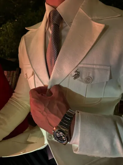 Another look at the details of the safari suit, highlighting the epaulets, pocket construction, and the client's personal styling with a watch and lapel pin.